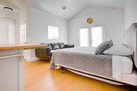 Smart open-concept layout — plush bed flows into a fully equipped kitchen, perfect for relaxed solo or couple stays.