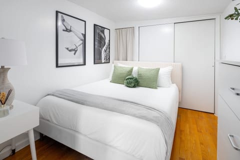 Stylish queen bedroom with plush linens & modern artwork