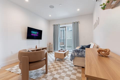 Smart TV living Smart TV viewing area with cozy seating in bright Scandinavian Bushwick 1BD apartmen