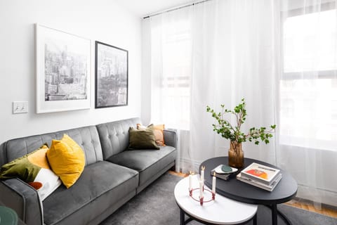 Modern living room with cozy sofa, bright accents, and natural light