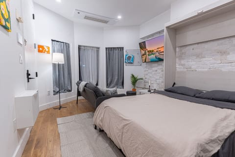 Bright, renovated studio with a comfortable bed and exposed-brick accent wall — your stylish, easy Brooklyn base just steps from the train.