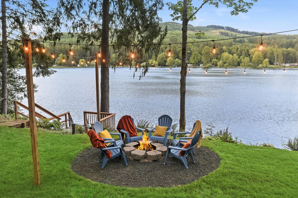 Lakeside fire pit with string lights and serene waterfront views