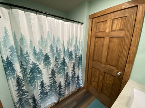 Cozy cabin-style bathroom with forest-inspired shower curtain