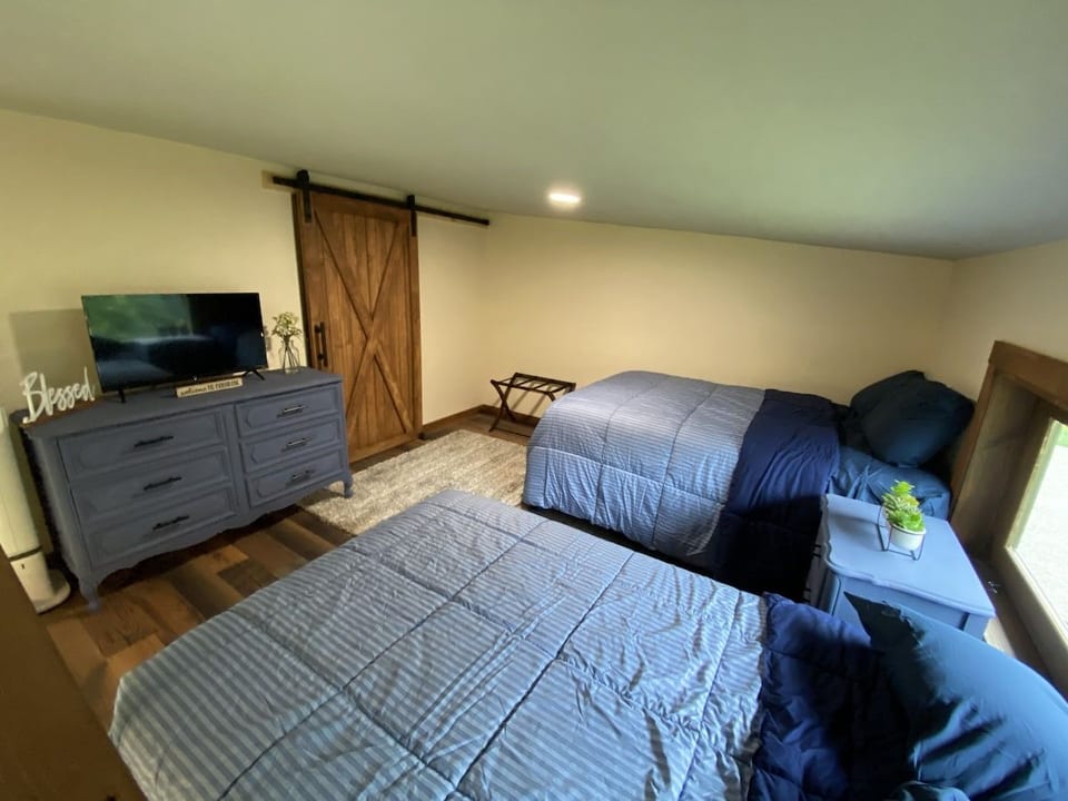 Cozy double-bedroom retreat with TV, barn door, and room for groups