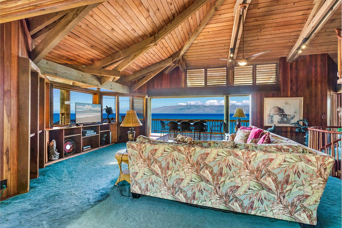 Large open space living room with high ceilings and a great spot to watch the game and whale's swim by.