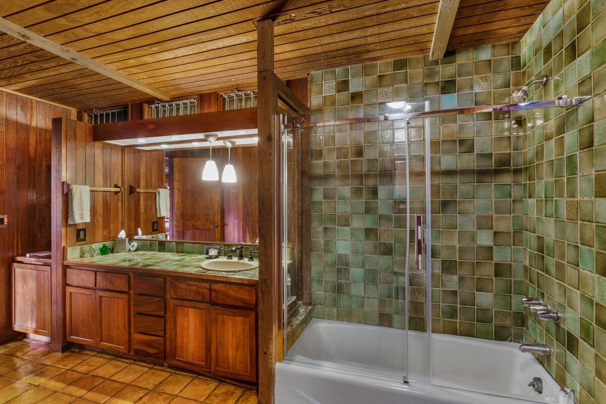 The emerald tile scheme continues downstairs in the master bath situated as an ensuite to the master bedroom and direct access from the downstairs living area as well.