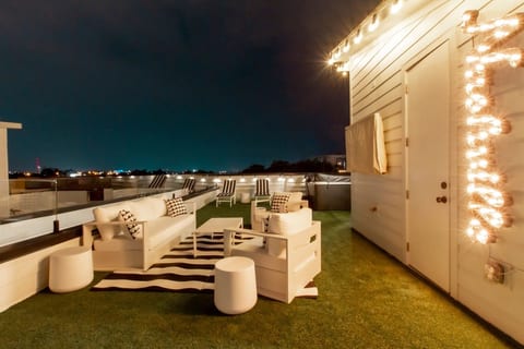 rivate rooftop terrace with full outdoor lounge seating and ambient night lighting.