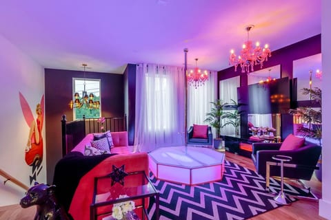 Vibrant indoor entertainment room with custom lighting, velvet seating, and eclectic decor.