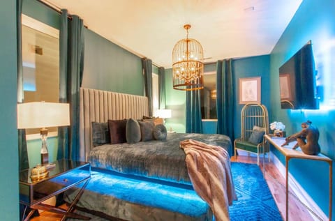 Bedroom suite with king bed, luxury furnishings, and elegant designer decor.