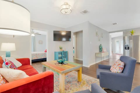Living room plus sofa bed, 50" Vizio TV including Netflix and Disney Plus. Teal cabinet below tv stocked with games such as Catch Phrase, Cards Against Humanity, Monopoly (San Antonio Edition), Candyland, Sorry, Dominoes and playing cards.