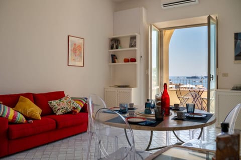 A charming seaside apartment featuring a bright living area, modern furnishings, and a balcony with stunning ocean views.