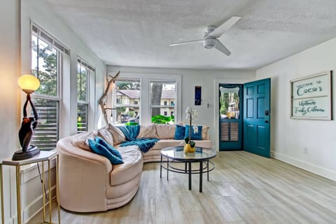 Bright, cozy living room with sunny windows and a stylish curved sofa.