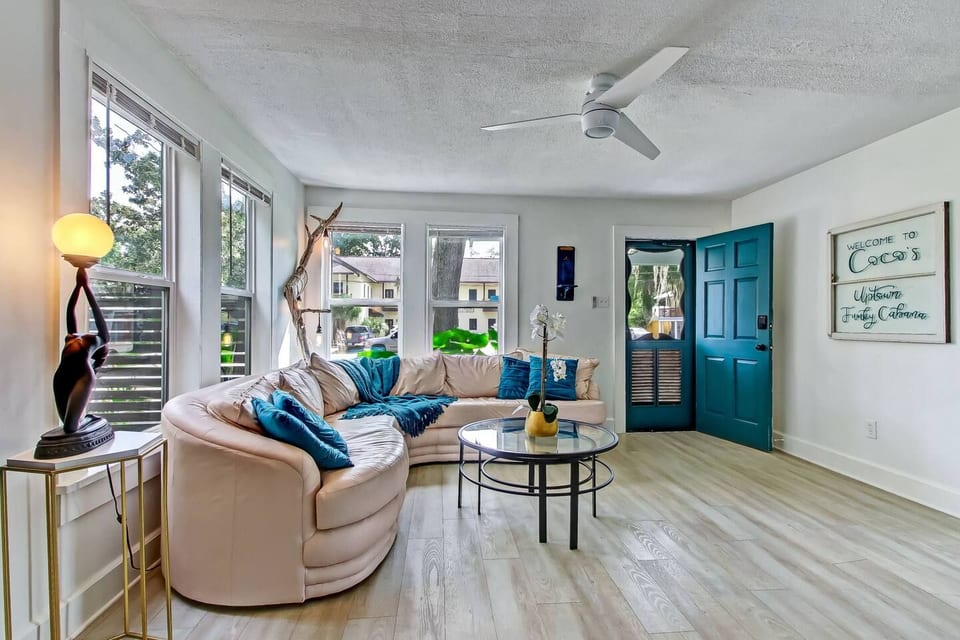 Bright, cozy living room with sunny windows and a stylish curved sofa.