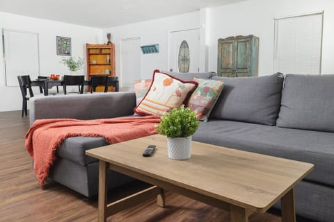 Cozy living room with a soft sectional sofa, warm décor, and a smart TV; an ideal space to unwind after exploring San Antonio’s top attractions.