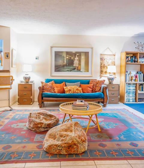 Cozy bohemian lounge with bookshelves, vintage artwork, and plush seating. Perfect for reading, relaxing, or gathering with friends in a warm, stylish, personality-packed space.