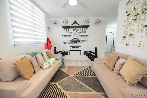 Bright and comfortable living room with smart TV, AC, and stylish décor, perfect for movie nights, gaming sessions, or chilling with your group. A welcoming space for fans and families alike.