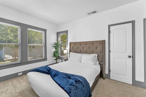 Spacious and peaceful bedroom with a cozy queen bed and natural light, designed for restful nights after busy days around the city.