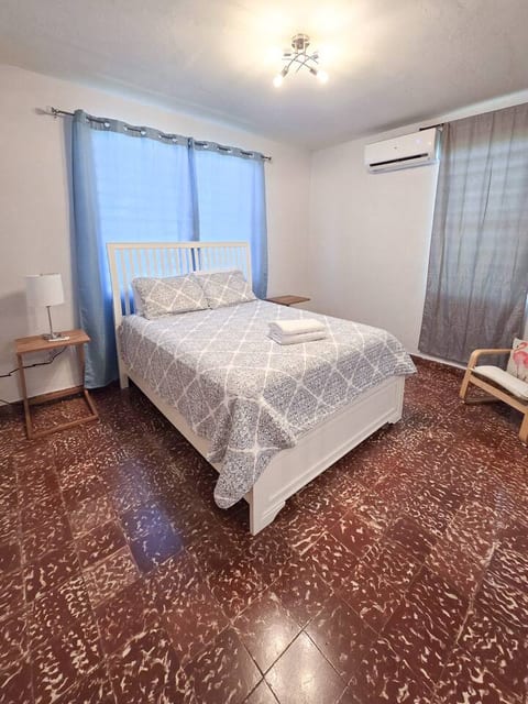 A welcoming, air-conditioned bedroom with crisp bedding and a calm, restful atmosphere.