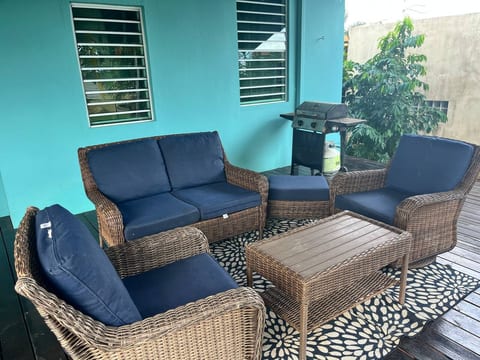 A comfortable outdoor lounge with plenty of seating and a grill ready for use