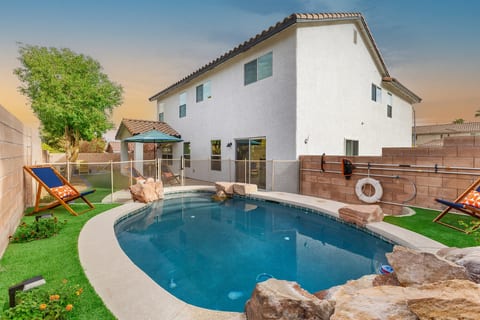 Our heated plunge pool with rock features and a waterwall is perfect in winter or summer. Fenced off for the safety of your children. Our covered patio and firepit can be seen beyond. -Adventure Awaits