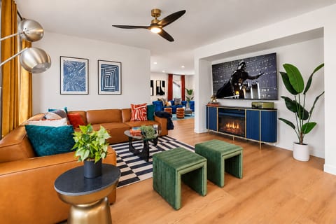 The second living room has a comfy sectional, a faux fireplace, and a 75" 4K TV. Put your feet up on the ottomans and enjoy a movie night with the whole group.