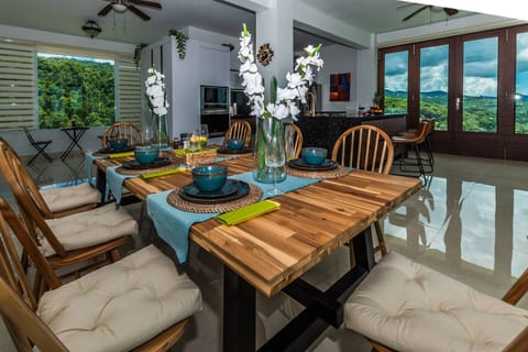 Stylish dining area designed for shared meals with rainforest and ocean scenery.