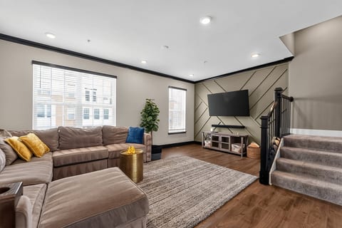 Bright, spacious living room with large sectional and stylish TV feature wall