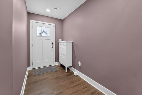 Bright, stylish entryway with frosted glass door and handy storage