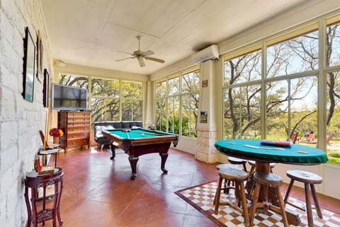 Game room with pool table, poker table, wide-screen TV, and large windows, space for family fun and group entertainment