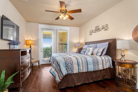 Spacious primary suite featuring a king bed, private balcony access, and a peaceful retreat after a day exploring Lake Travis