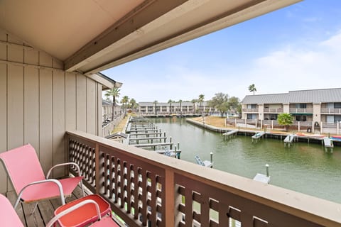 Covered balcony seating overlooking the water, perfect for coffee, conversation, or relaxing after the beach.