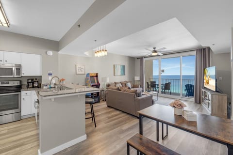 Open-concept layout seamlessly connects the kitchen, dining area, living room, and private Gulf-view balcony for effortless coastal vacation living.
