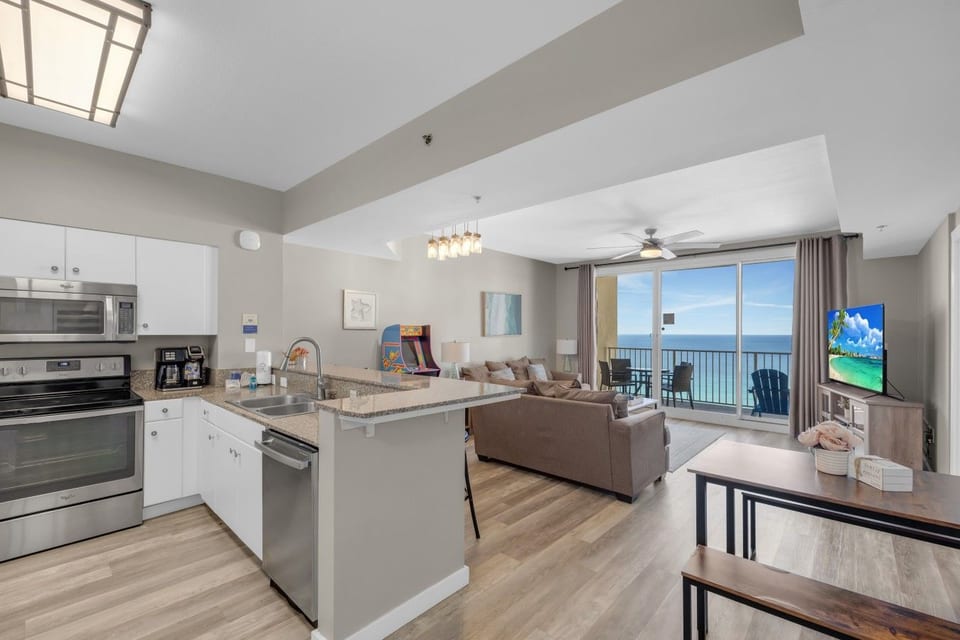 Open kitchen with granite countertops overlooks the living area and leads to a private balcony with beautiful Gulf views through expansive sliding glass doors.