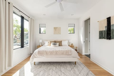 Master suite headboard — macramé wall art, premium linens, ceiling fan, blackout curtains — hotel-quality sleep inside a real home