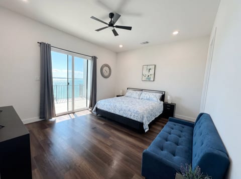 Bright waterfront bedroom with private balcony and serene water views