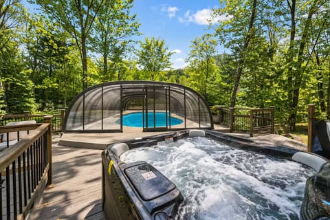 Relax in the private outdoor hot tub overlooking the trees, steps from the pool and lounge area. Perfect for unwinding after a day of adventure-ideal year-round for cozy evenings under the stars.