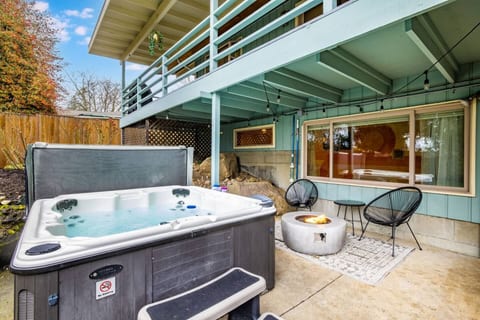 Shared outdoor space with a hot tub, fire pit, cozy seating area, and covered patio — perfect for relaxing and unwinding.
