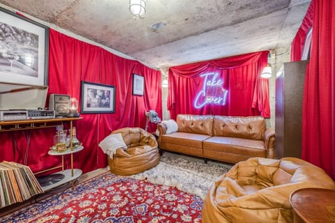 Bomb shelter turned cozy speakeasy – vintage vibes, plush seating, a record player, and a stocked bar for the perfect hideaway!