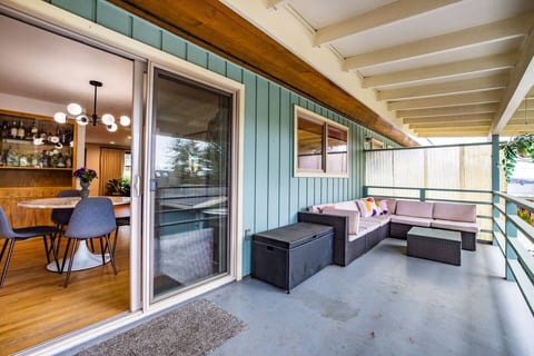Spacious balcony with cozy seating, a glass-top table, and a relaxing open-air vibe.