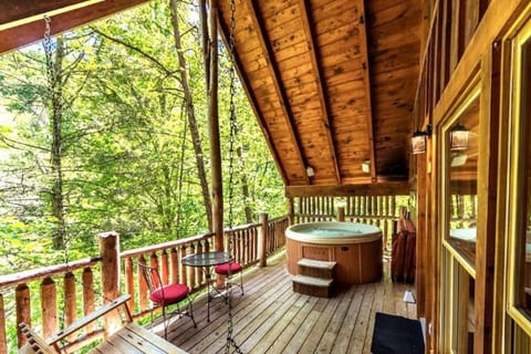 Back deck with a view, swing, sitting area, and hot tub!