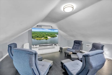 Finished attic with 85" Smart TV can be used as theater room, office space or even extra sleeping space on pullout futon