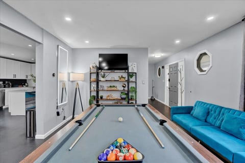 Professional pool table in living room with smart TV and plenty of seating