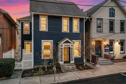 Welcome to the your cozy retreat, featuring the charming house facade with a white wooden fence on the left, leading you to Unit 2.