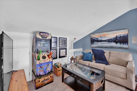 Loft game room with endless entertainment! 🎮🕹️ Enjoy board games, arcade fun, and a pull-out couch for extra sleeping space. Perfect for relaxing after a day of adventure! (Note: Big Buck Hunter no longer available and replaced with Pac-Man arcade)