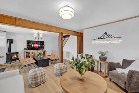 Cozy basement lounge with plenty of seating, a Smart TV, and a wood-burning fireplace—perfect for relaxing after a day by the lake.