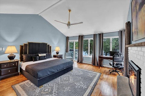 Master bedroom retreat with everything you need — ceiling fan, fireplace, workspace, and stunning lake views.