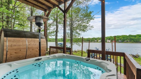 Soak in the private hot tub tucked under the deck, overlooking stunning lake views—perfect for relaxing day or night.