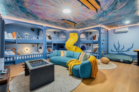 The ultimate bunk room & play space! Featuring 6 queen-size bunk beds, this fun-filled room is perfect for kids, teens, and groups to sleep, play, and make unforgettable memories together.
