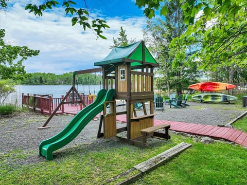 A family-friendly backyard featuring a swing and slide set, designed to keep kids entertained while you relax.