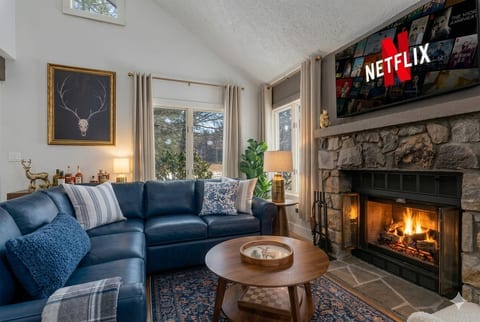 Cozy up by the fireplace, perfectly framed by the beautiful glass windows—bringing warmth and scenic views to the heart of the living room.